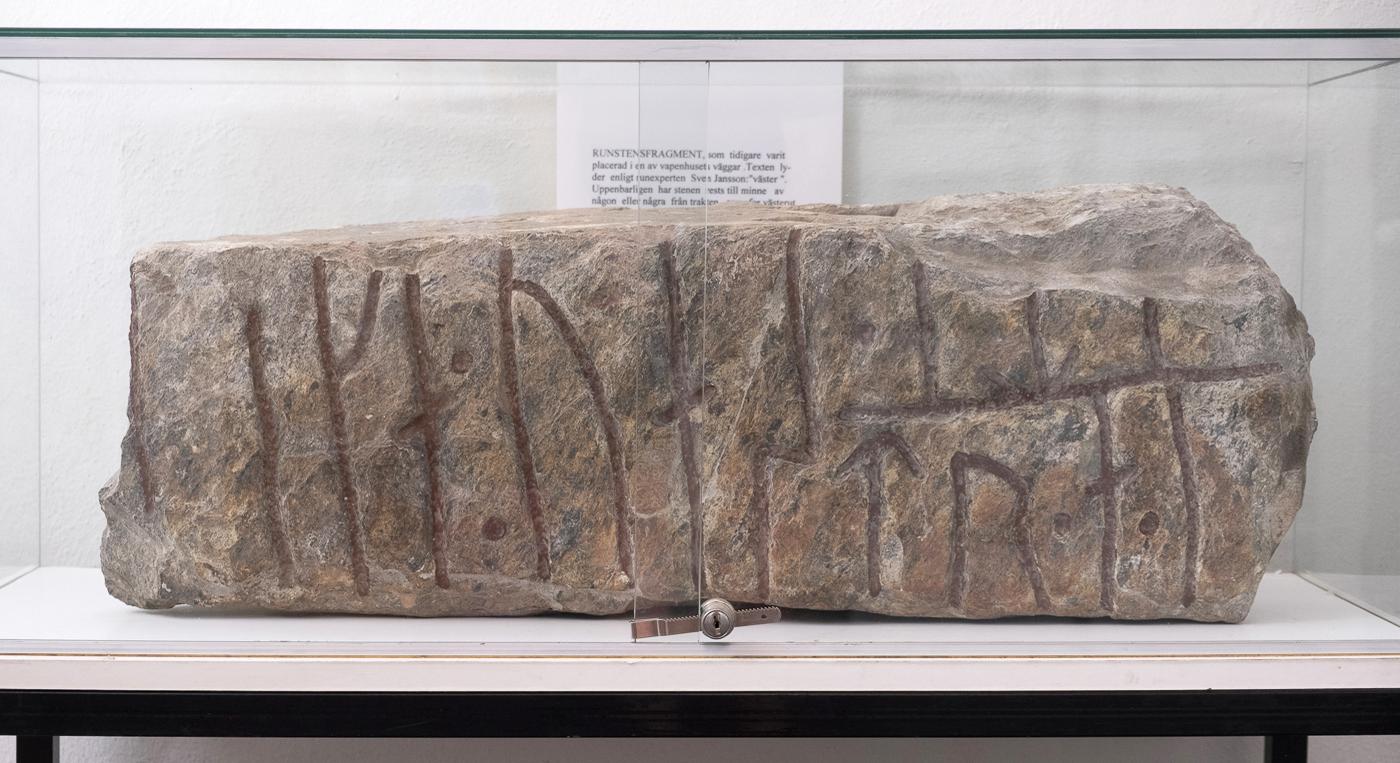 En stor runsten visas upp i en glasmonter.