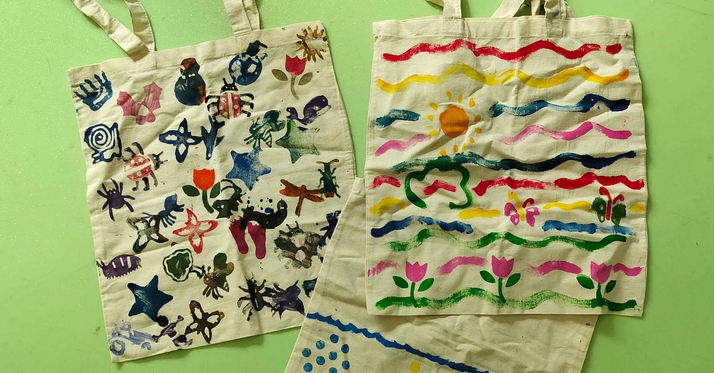Bilden visar tre tygkassar med personlig design och tryck skapad av museibesökare i olika åldrar.