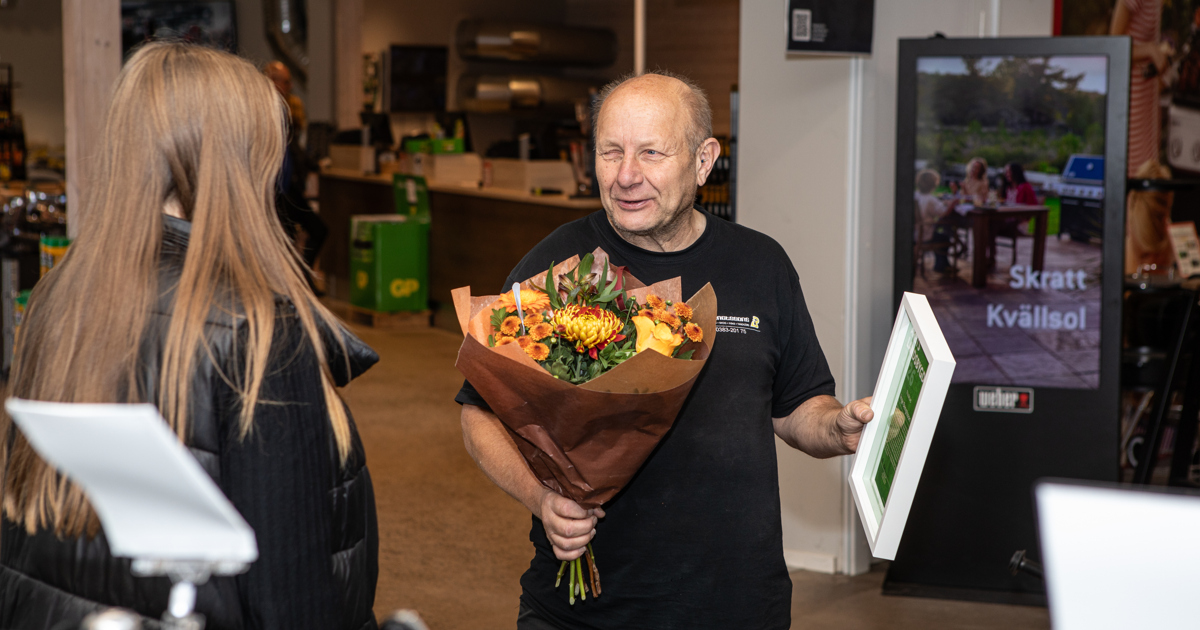 En man håller en bukett blommor.