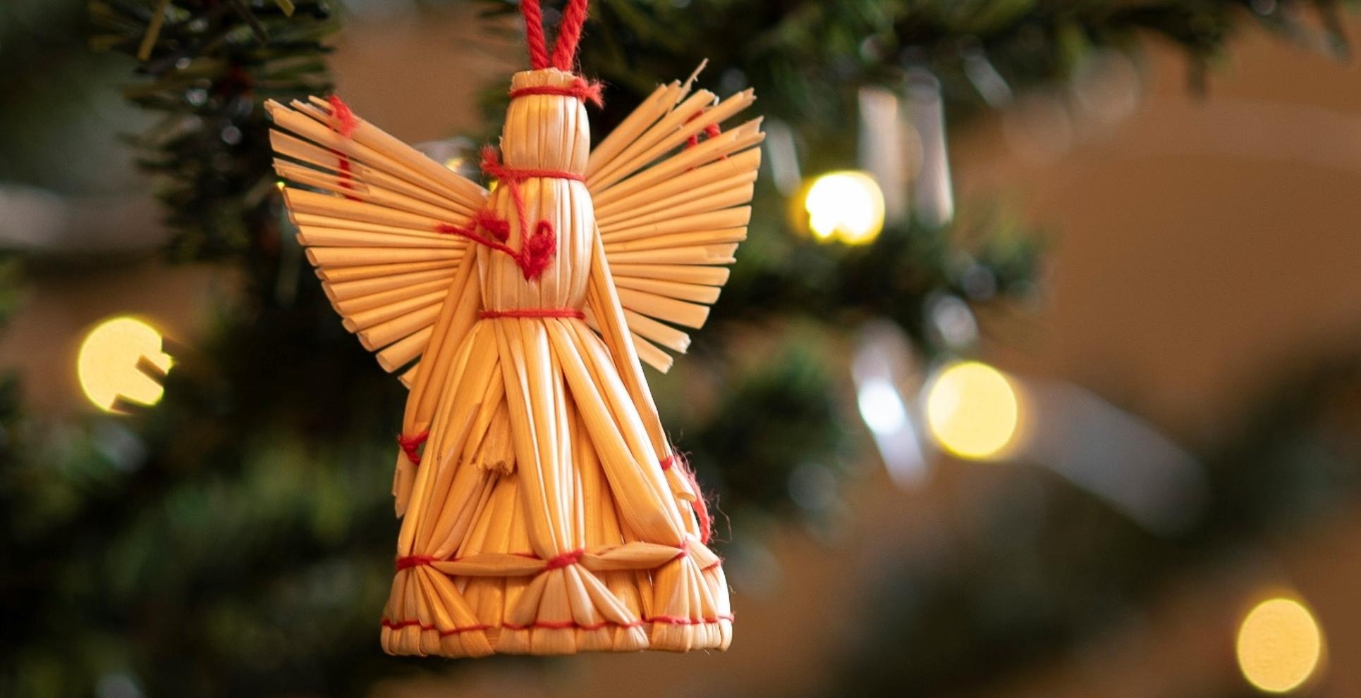 En ängel i halmslöjd hänger i en julgran
