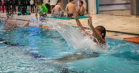 En grupp människor som leker i en simbassäng.