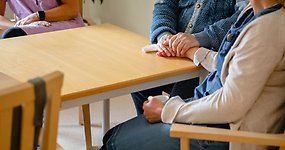 En grupp människor som sitter runt ett träbord.